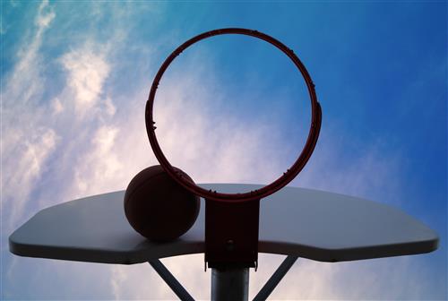 Basketball stuck against basketball hoop and backboard 