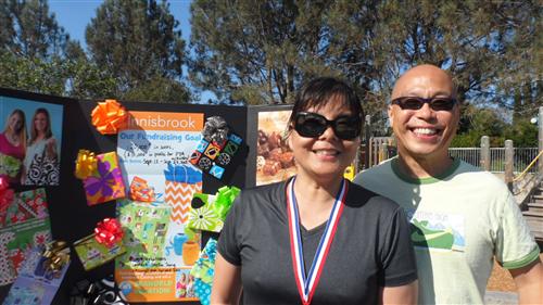 Parents smiling in front of a banner