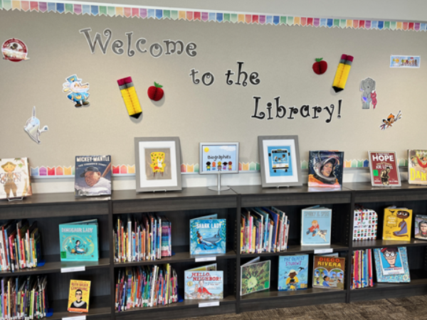 Biography book shelves with a bulletin board that says Welcome to the Library