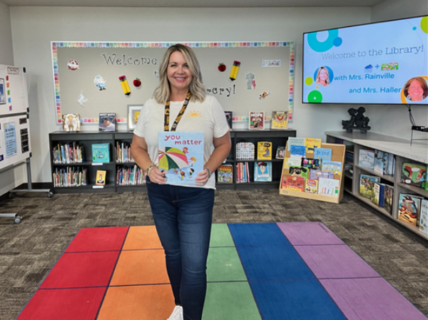 School Librarian holding a book in reading nook
